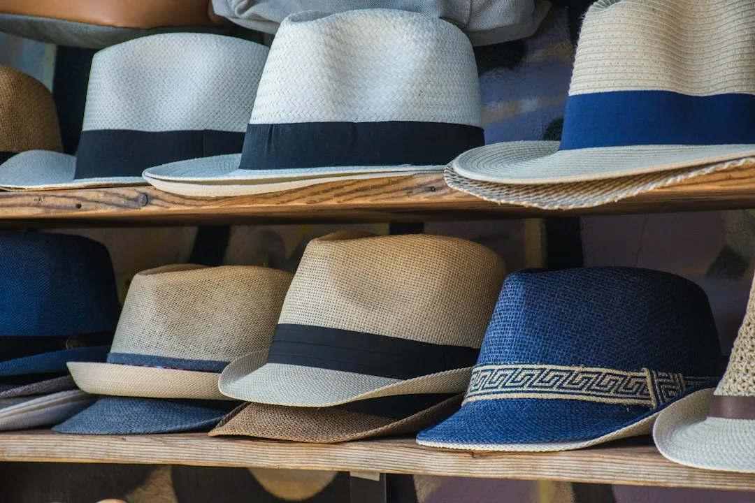 Wide-brim straw sun hats arranged on a light surface